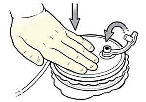 Closeup of gloved hand pressing down on hemovac drain. Arrow indicates stopper being closed.