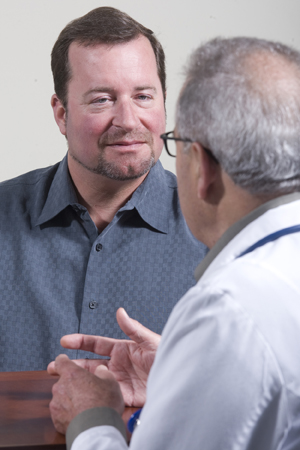 Man and healthcare provider sitting across from one another, talking.