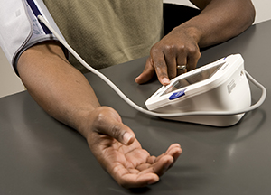 Man using home blood pressure monitor.