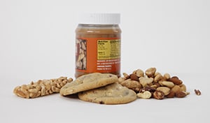 Granola bar, jar of peanut butter, cookies, and mixed nuts.