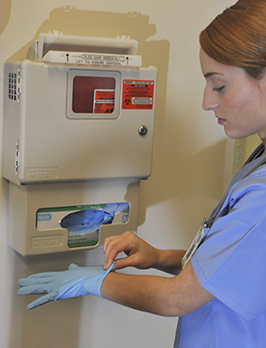 Healthcare provider putting on surgical gloves.