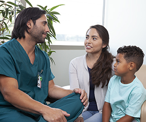 Un proveedor de atención médica habla con una mujer y un niño.